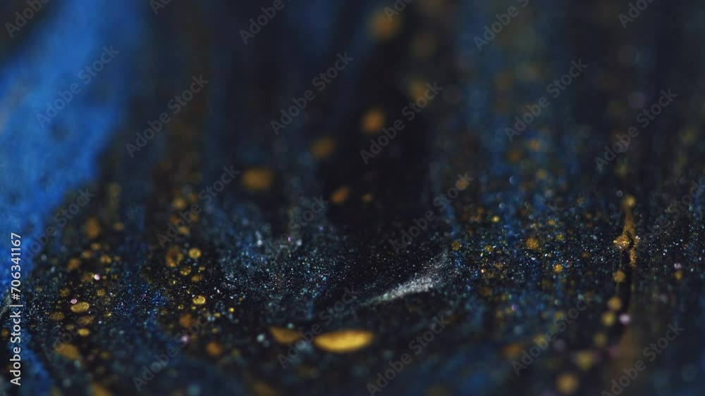 Glitter fluid texture. Sparkling paint flow. Blur blue black gold color shiny ink water cascade wave motion on dark abstract art background.