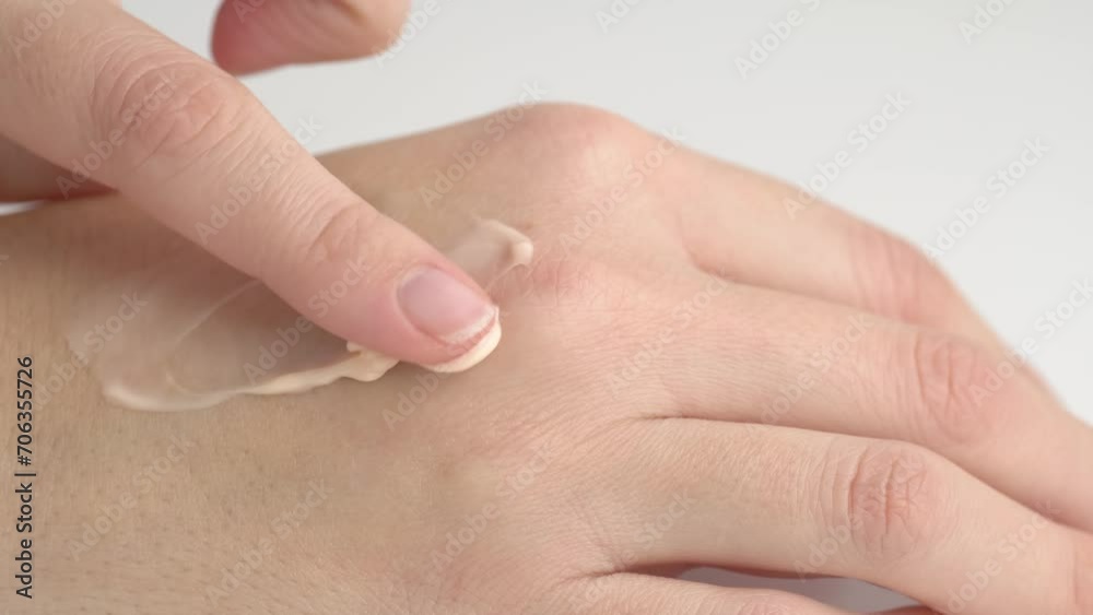 Female hands care. Close up of woman applying cream on hand skin. Skin care cosmetics in peach fuzz color, moisturizing gel. Female hands care. Close up of woman applying cream on hand skin. Skin care cosmetics in peach fuzz color, moisturizing gel.