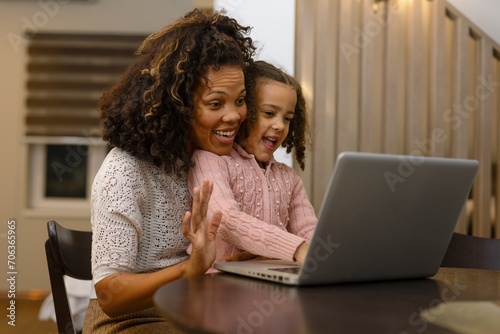 African american mother and daughter using a laptop computer at home.