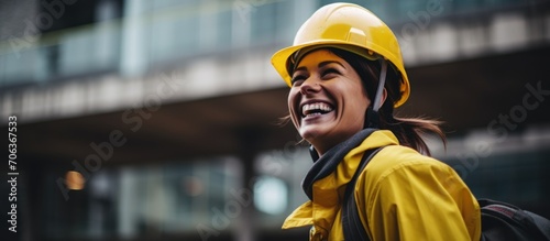 Joyful woman happily celebrates in a contemporary city, stylishly attired, wearing a yellow helmet for protection. photo