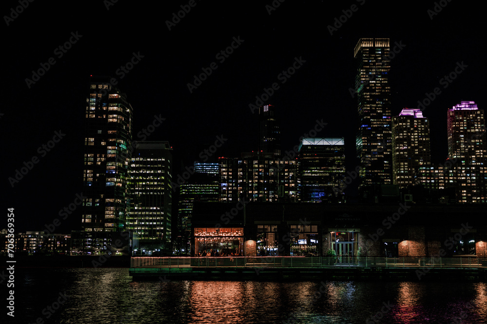the city skyline at night, showing illuminated lights and reflections