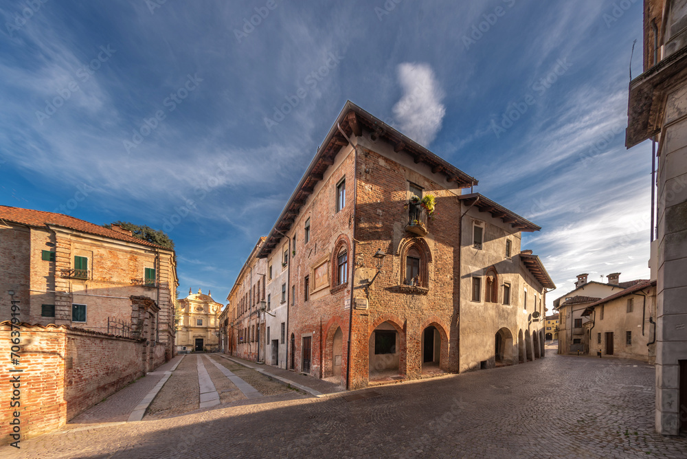Carignano, Turin, Italy - Panorama view between Via Frichieri and Via Monte di Pietà with a house of medieval origin with Gothic windows and in the background the church of San Giuseppe