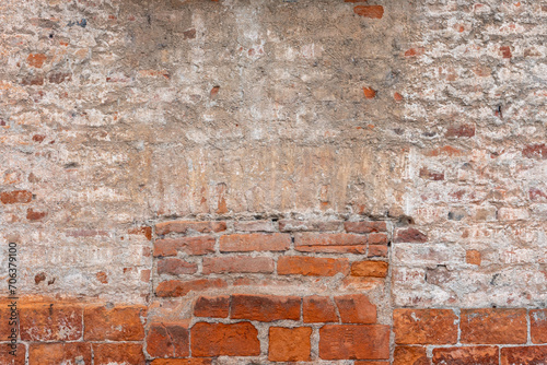 Old wall texture with plaster and peeling background with exposed brick. Background of wall with plaster and brick and walled window with brick. Ideal for background with space for copies
