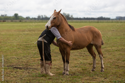 gaucho hugging his horse in the middle of the field © Santa001