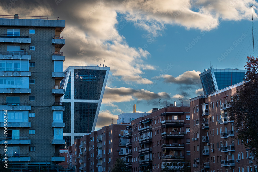 Architectural contrast in a cityscape with apartment buildings and modern office towers in financial districts in the city of Madrid in Spain