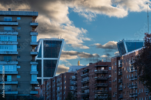 Architectural contrast in a cityscape with apartment buildings and modern office towers in financial districts in the city of Madrid in Spain photo