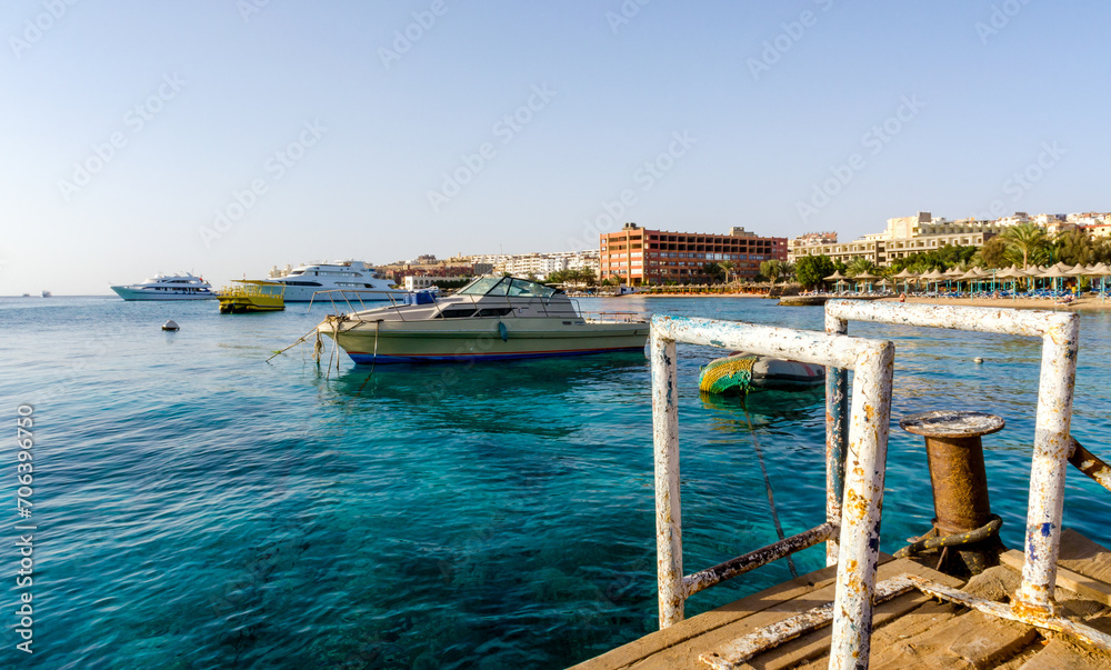 beach umbrellas and palm trees on the background of the red sea and ships in egypt