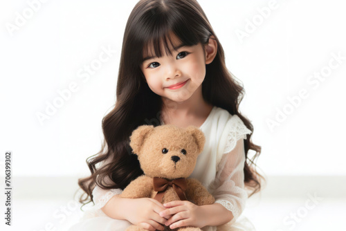 A cute girl playing with a teddy bear with copy space for text on solid white background. ai generative © Igor