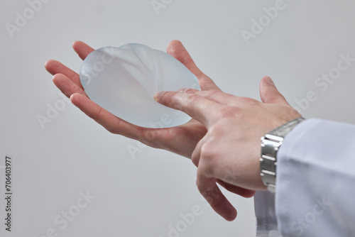 silicone breast implant in the hand of a plastic surgeon doctor, mastopexy concept, BREAST LIFT photo