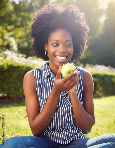 African American Female eating apple in the park