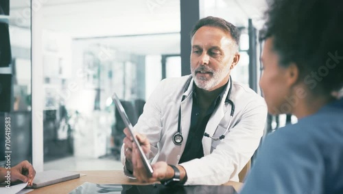 Man, doctor and tablet in discussion with nurses, interns or medical employees at hospital. Surgeon or healthcare professional talking to staff of practitioners with technology for meeting at clinic photo