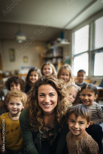Portrait of a smiling female teacher in the classroom with little children.