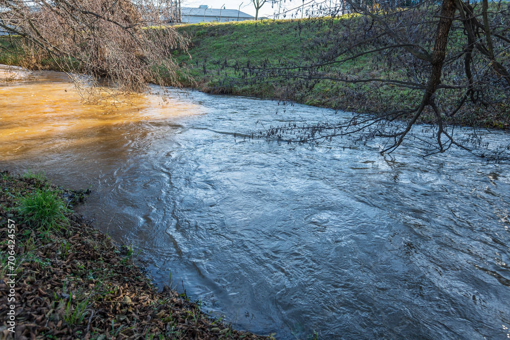 Fototapeta premium Rised water level in the creek after snow melted. Flood risk. Global warming concept