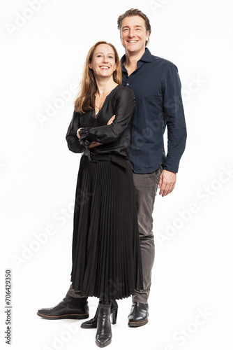 Portrait of elegantly dressed married couple wearing black evening attire. Studio shot