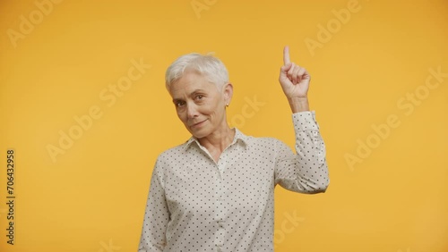 Senior Woman with Idea on Yellow photo