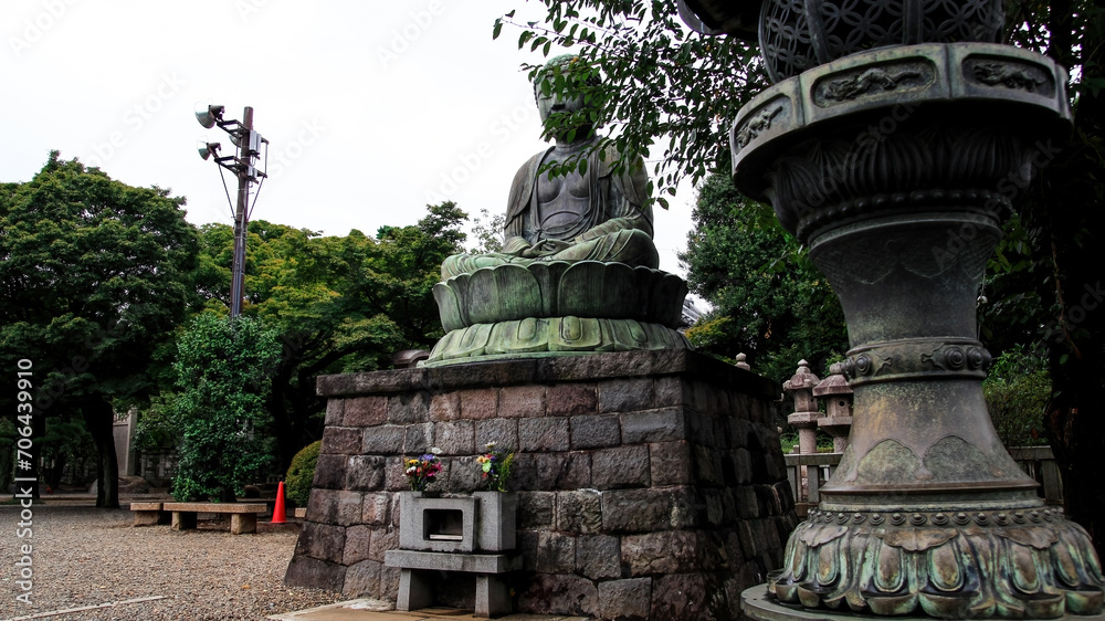 Obraz premium A bronze statue of Dainichi Norai, the Great Sun Buddha, near the Gokoku-ji Buddhist Temple. Ikebukuro, Tokyo, Japan