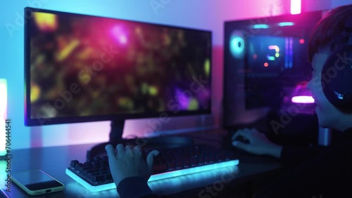Young gamer playing e-sport video game competition online inside gaming room. Multiplayer, gaming technology concept