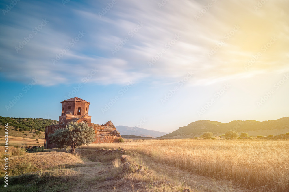 Red church ruins in Nigde province, sunset colors and clouds in the sky and sun light