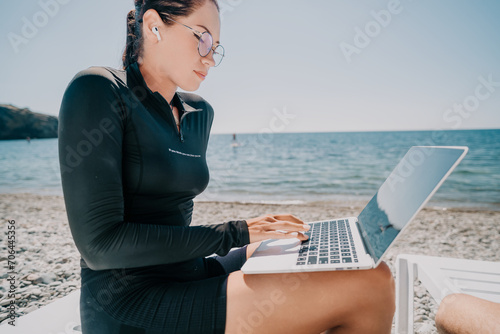 woman laptop sea. Working remotely on seashore. Happy successful lady, freelancer working on sea beach, relieves stress from work to restore life balance. Freelance, remote work on vacation