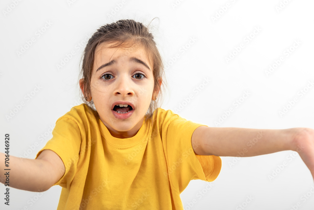 Surprised little girl throws up her hands, isolated on a white. Surprised little girl throws up her hands, isolated on a white.