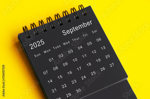 September 2025 black and white desk calendar on yellow cover background. Calendar concept