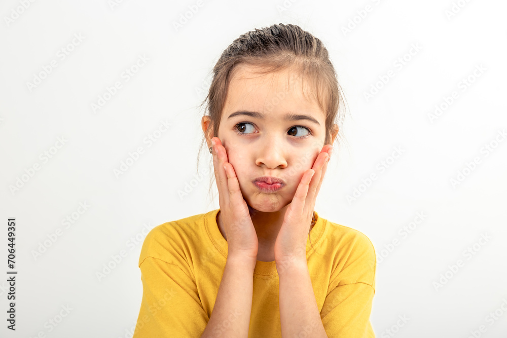 Little Caucasian girl makes funny faces on a white background isolated. Little Caucasian girl makes funny faces on a white background isolated.