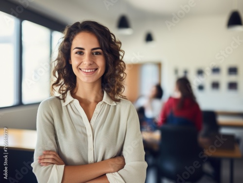 smiling teacher standing in classroom with arms crossed.