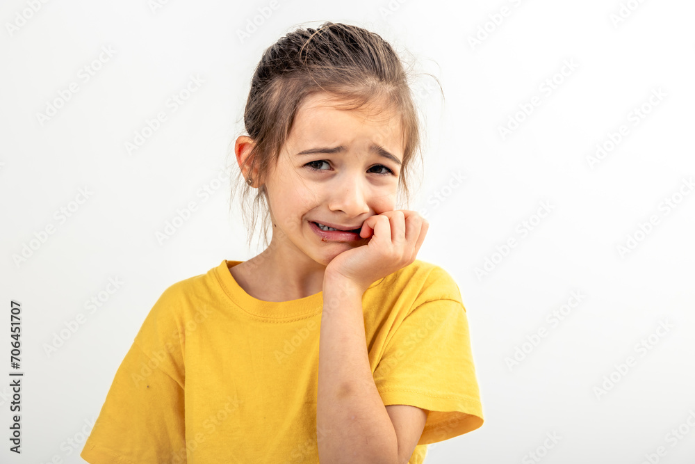 Scared and anxious girl, biting her fingernails on a white background isolated. Scared and anxious girl, biting her fingernails on a white background isolated.