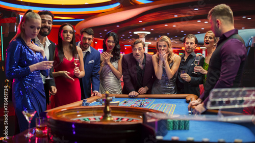 Casino Players Making Bets at a Roulette Table. Vibrant Crowd of International Young People Enjoying Nightlife in a City. Gamblers Excited About Successful Bets and Winning a Big Sum of Money