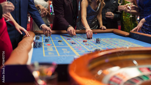 Anonymous Group of Elegant Casino Guests Placing Bets on a Table. Close Up Footage of a Spinning Roulette Wheel with a Ball Stopping at Lucky Number
