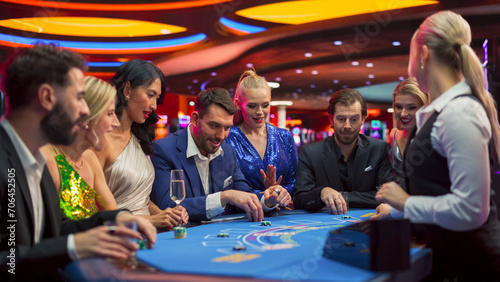 Group of Casino Goers Enjoying Time in a Modern Casino, Friends Placing Blackjack Bets, Professional Female Croupier Deals Cards. Diverse Group People Playing, Placing Bets Winning and Celebrating photo