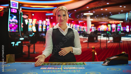 Professional Female Croupier in Casino Dealing Playing Cards on a Baccarat Table. Beautiful Dealer of a Live Online Casino Reveals Winning Results of the Card Game Bets, Looking at Camera
