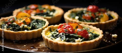 Spinach, feta, and tomato tartlets with garlic and cheese.