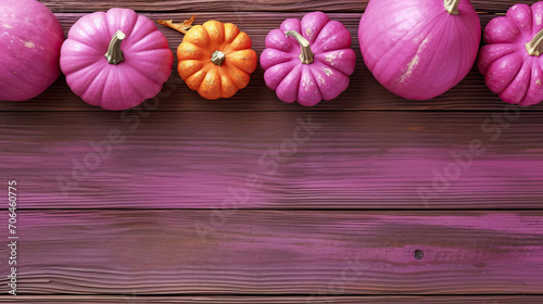 A group of pumpkins on a magenta color wood boards