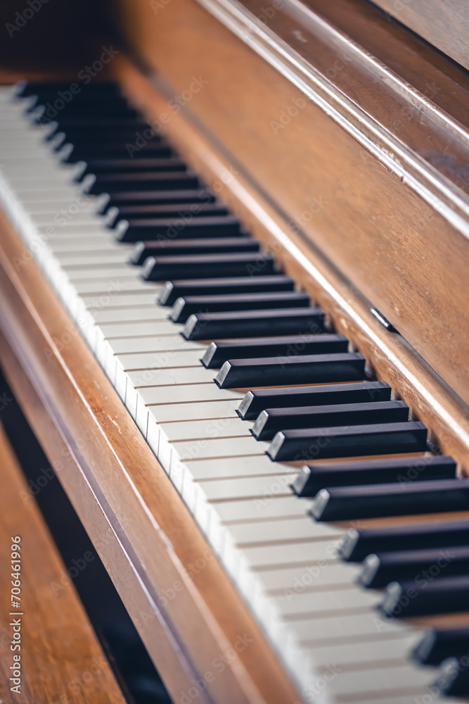 Piano keys on wooden brown musical instrument.