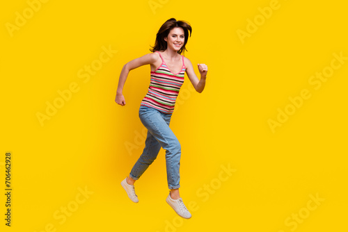 Fototapeta Naklejka Na Ścianę i Meble -  Full size photo of energetic gorgeous woman dressed knit top jeans run shopping to empty space isolated on yellow color background