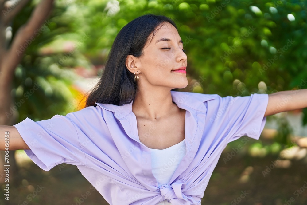 Young beautiful hispanic woman breathing with closed eyes at park Young beautiful hispanic woman breathing with closed eyes at park