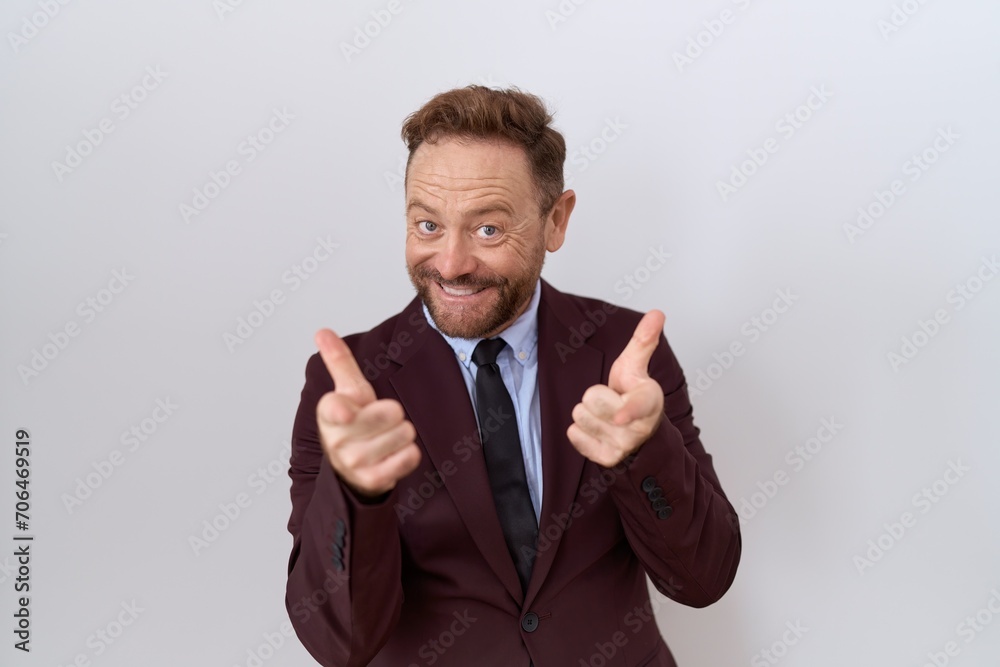Middle age business man with beard wearing suit and tie pointing fingers to camera with happy and funny face. good energy and vibes. Middle age business man with beard wearing suit and tie pointing fingers to camera with happy and funny face. good energy and vibes.