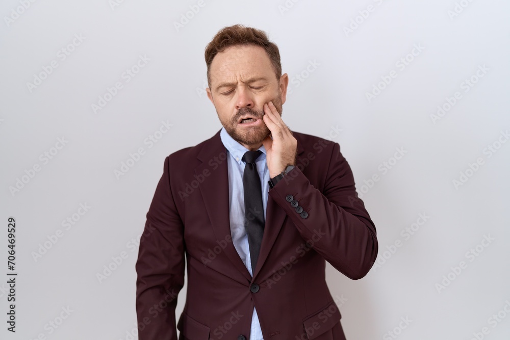 Middle age business man with beard wearing suit and tie touching mouth with hand with painful expression because of toothache or dental illness on teeth. dentist Middle age business man with beard wearing suit and tie touching mouth with hand with painful expression because of toothache or dental illness on teeth. dentist