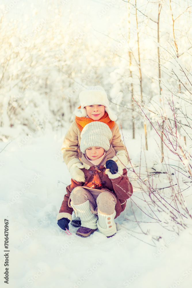 Children play in a winter snowy forest.