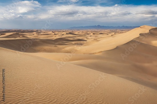 A vast desert landscape with rolling sand dunes and a bright blue sky