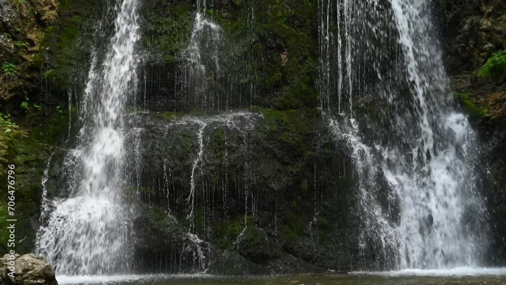Closeup of a twofold waterfall in a forest (slow motion) Closeup of a twofold waterfall in a forest (slow motion)