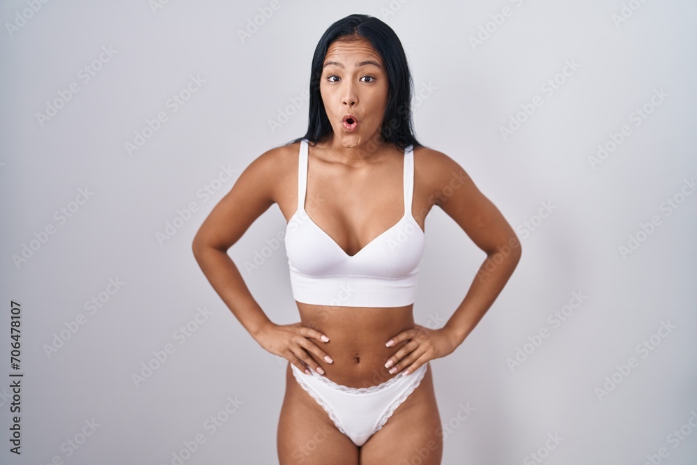Fototapeta premium Hispanic woman wearing lingerie afraid and shocked with surprise and amazed expression, fear and excited face.