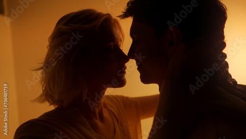 Lovely couple kissing and touching each other during romantic date in orange neon light studio 