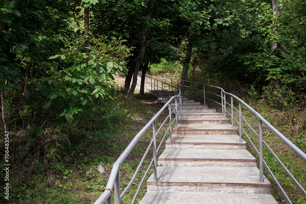 Picturesque staircase with iron railings in the city park. Image for your creative design or illustrations about nature and leisure.