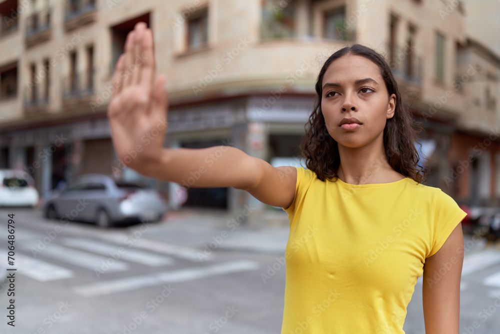 Young african american woman doing stop gesture with hand at street