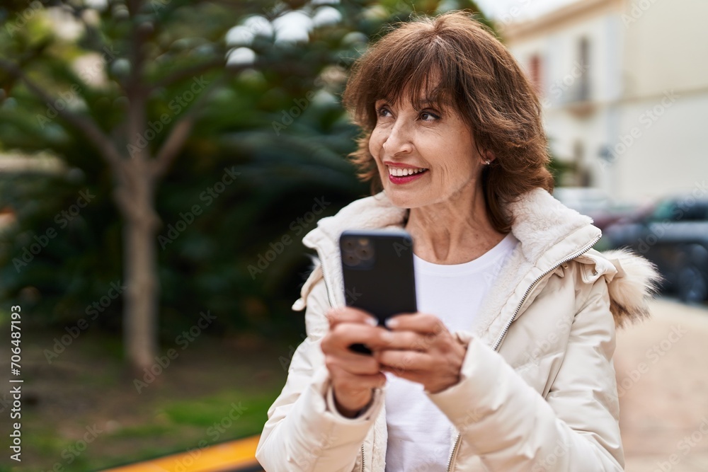Middle age woman smiling confident using smartphone at park Middle age woman smiling confident using smartphone at park