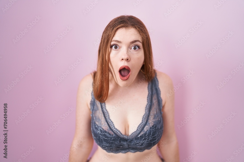Φωτογραφία Redhead woman wearing lingerie over pink background afraid and shocked with surprise and amazed expression, fear and excited face