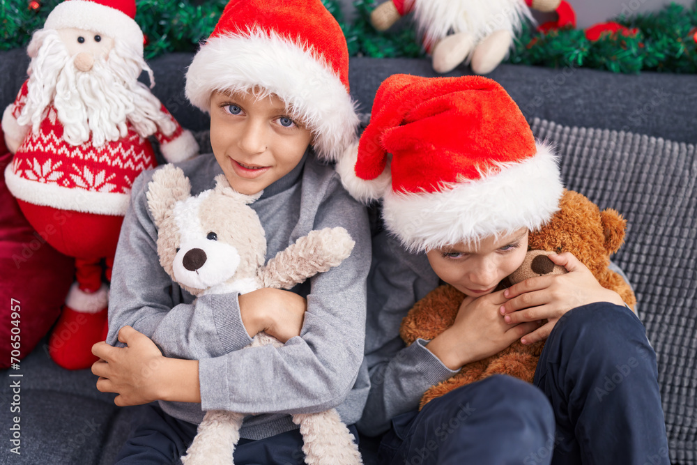 Adorable boys hugging teddy bear celebrating christmas at home