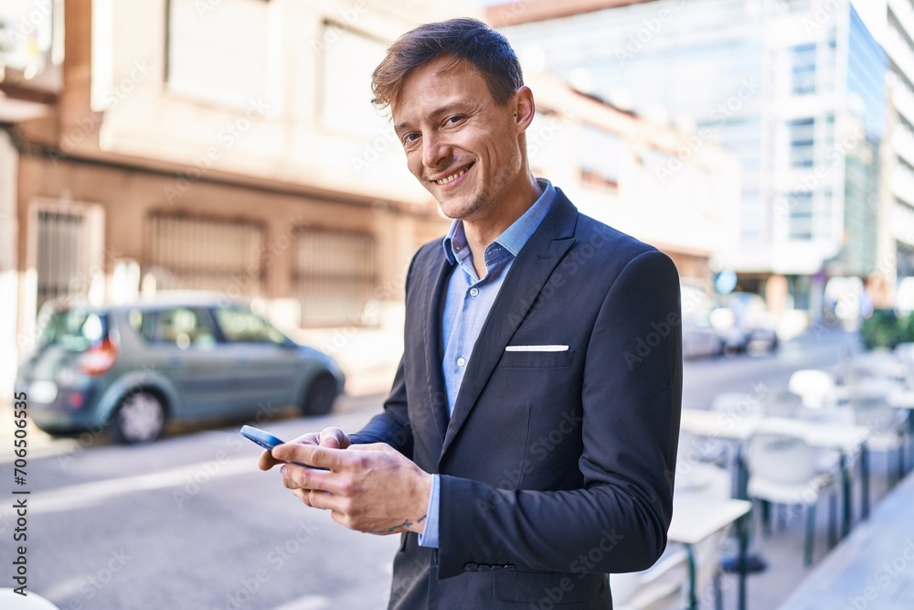 Young man business worker smiling confident using smartphone at street